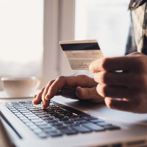 Man,Holding,Credit,Card,And,Using,Laptop.,Businessman,Or,Entrepreneur